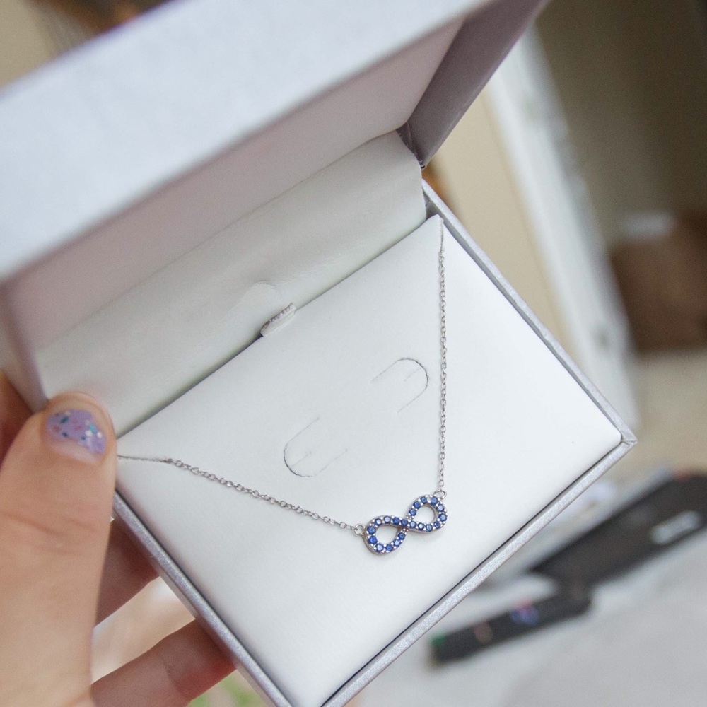 Silver infinity sign neck lace with blue gems